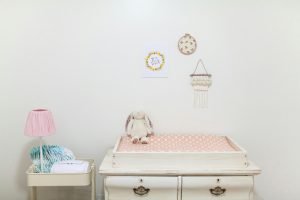 Un joli coin nursery minimaliste avec une table à langer et un jouet en peluche.