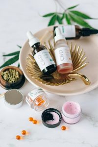 Elegant display of various CBD products including oils and creams with a natural backdrop. Présentation élégante de divers produits CBD incluant des huiles et des crèmes sur un fond naturel.
