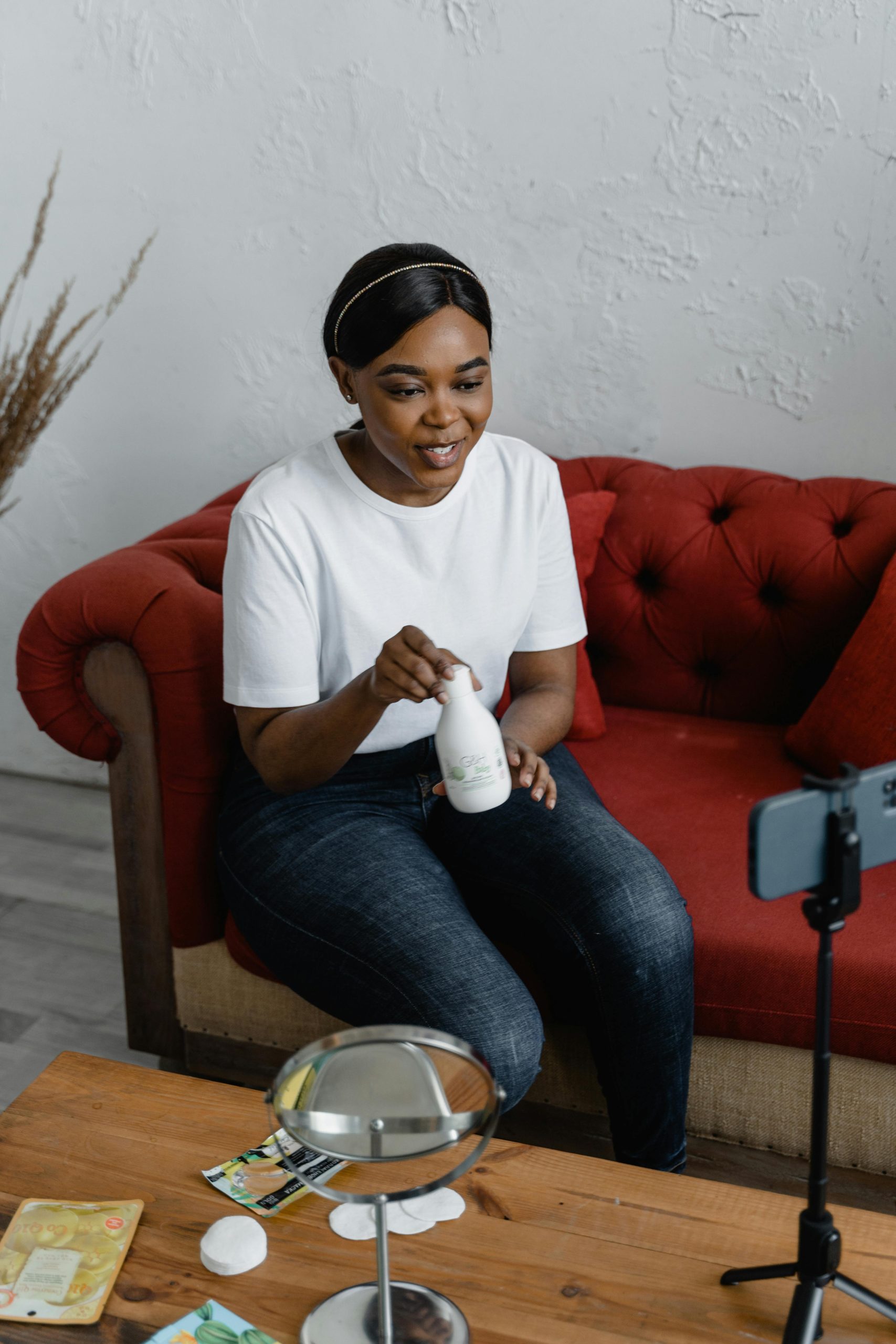 Woman recording a beauty product review for social media at home. Femme enregistrant un avis sur un produit de beauté pour les réseaux sociaux à la maison.
