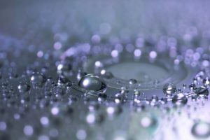 Captivating macro photograph of water droplets highlighting reflection and clarity. Photographie macro captivante de gouttes d'eau mettant en évidence la réflexion et la clarté.
