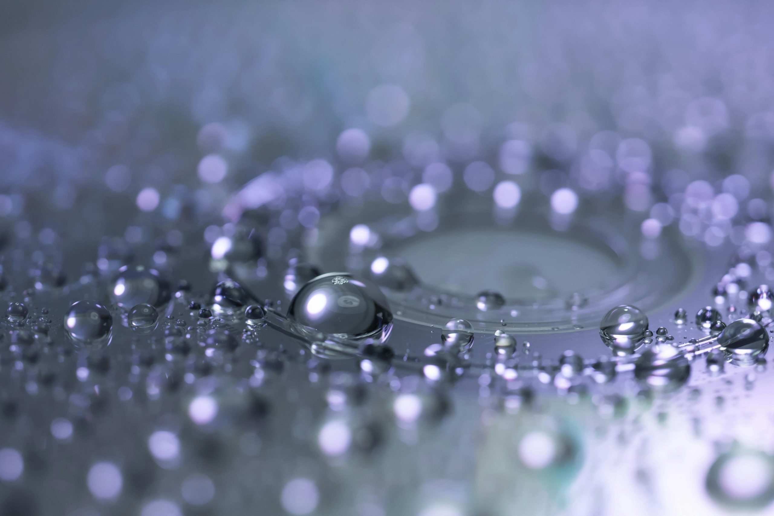 Captivating macro photograph of water droplets highlighting reflection and clarity. Photographie macro captivante de gouttes d'eau mettant en évidence la réflexion et la clarté.