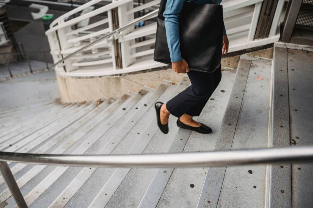 Femme portant un sac en cuir noir dans la rue