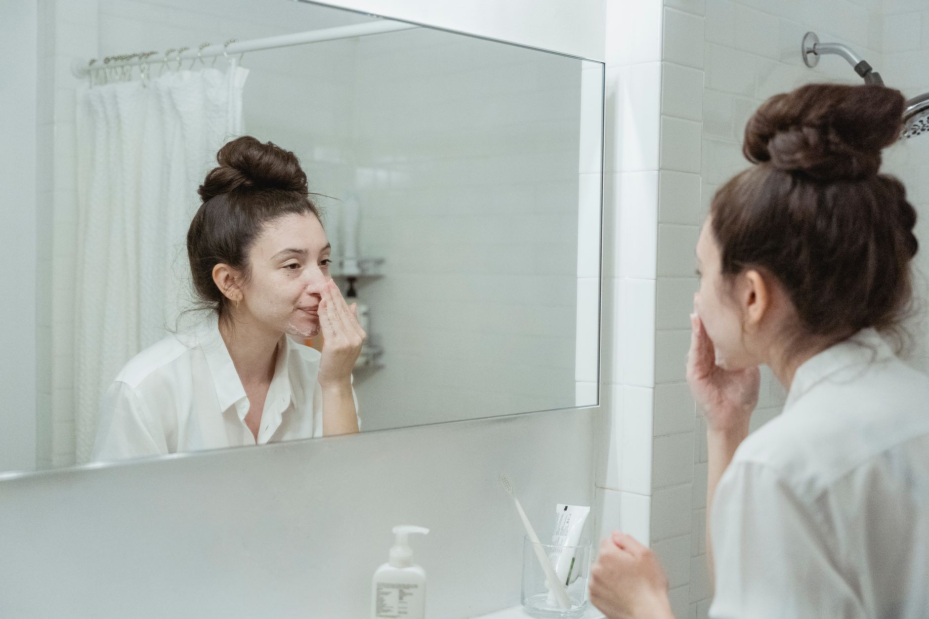 Application d'un soin du visage devant le miroir