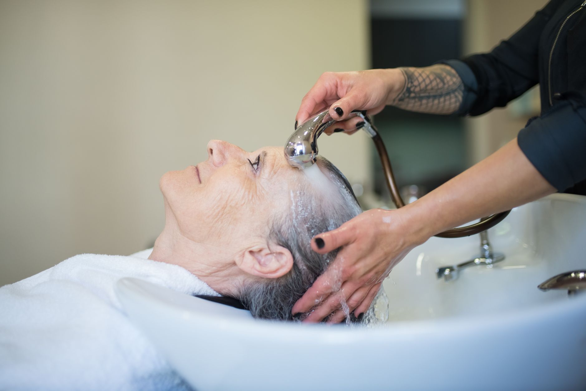 Shampoing appliqué sur les racines lors d'un lavage en institut