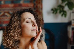 Femme aux cheveux bouclés profitant d'une routine de soin
