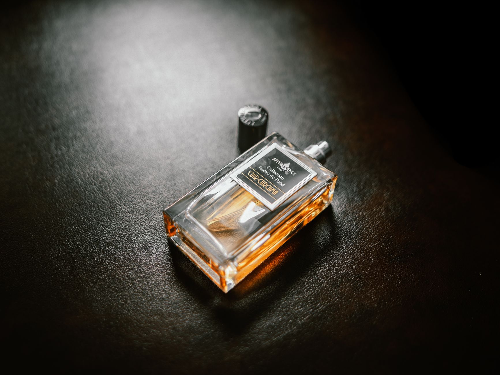 Flacon de parfum ambre sur fond sombre